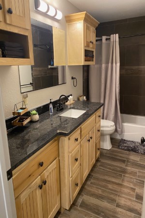 Full bathroom with tub and shower combo next to the Twin XL bedroom, attached to the living room