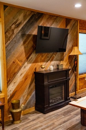 Real reclaimed wood accent wall with large flatscreen Samsung Smart TV & electric heater fireplace